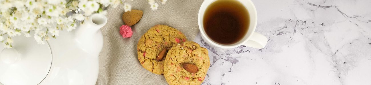 Photo culinaire d'un cookie pralines roses et amandes avec une tasse de thé