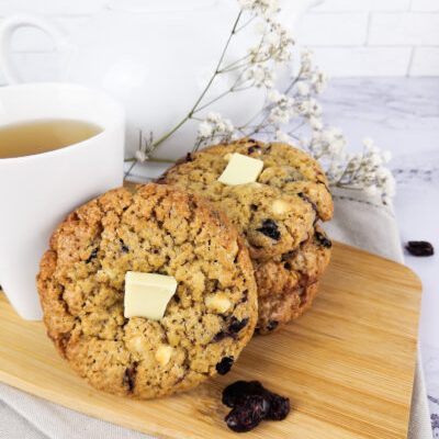 Cookies au chocolat blanc et cranberries-3 Cookies au chocolat blanc et cranberries présentés sur une planche en bois - La Petite Fabrique Gourmande
