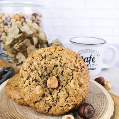 Gros plan d'un cookie aux noisettes et au pralin présenté sur une planche